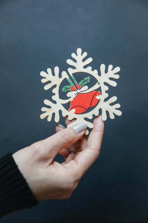 拿着蓝色和白色花卉贴纸的人 · 免费素材图片