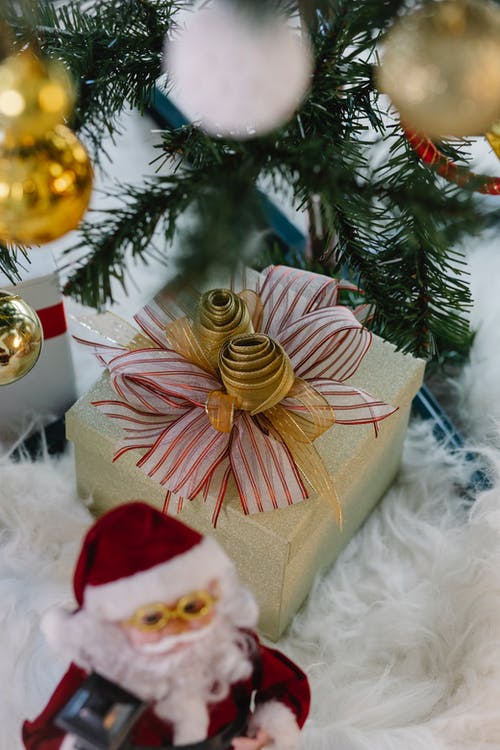 白色纺织品上的金色和红色圣诞小玩意 · 免费素材图片