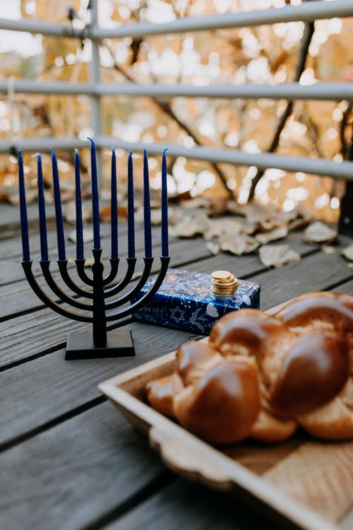 面包在烛台旁边的木托盘上的照片 · 免费素材图片