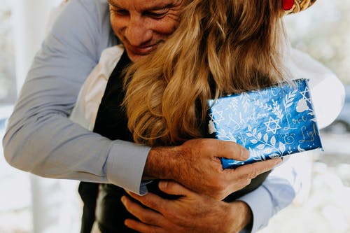 拥抱一个女人的男人的特写照片 · 免费素材图片