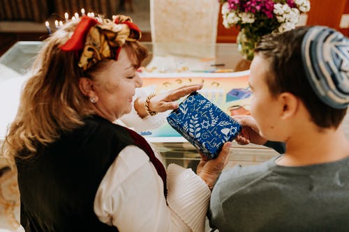 母亲递礼物给她的儿子的照片 · 免费素材图片