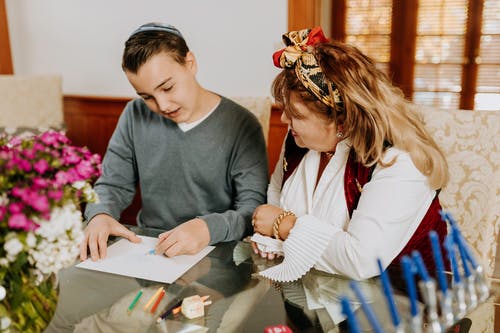 母亲看着儿子工作的照片 · 免费素材图片