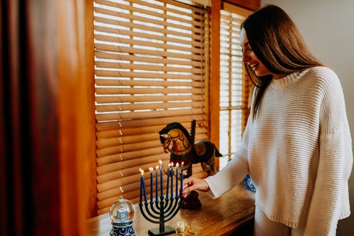 女人抱着一支点燃的蜡烛的照片 · 免费素材图片