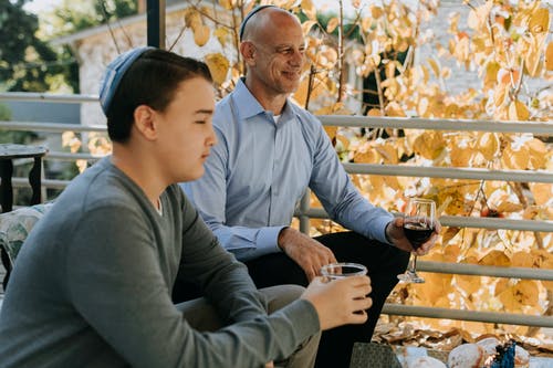 父亲和儿子坐在彼此旁边的照片 · 免费素材图片