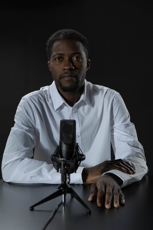 拿着黑照相机的白色礼服衬衣的人 · 免费素材图片