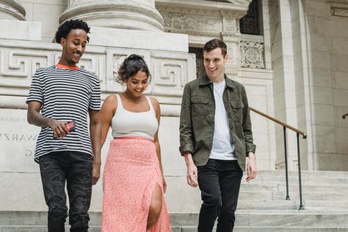 灰色衬衫的男人站在红色的管裙的女人旁边的衬衫的男人 · 免费素材图片