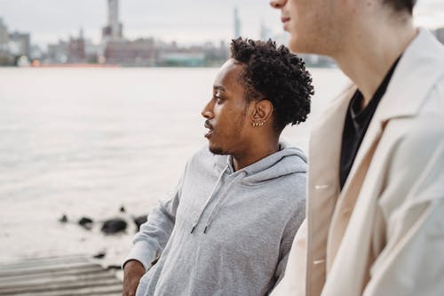 站在白色外套的女人旁边的灰色连帽衫的男人 · 免费素材图片