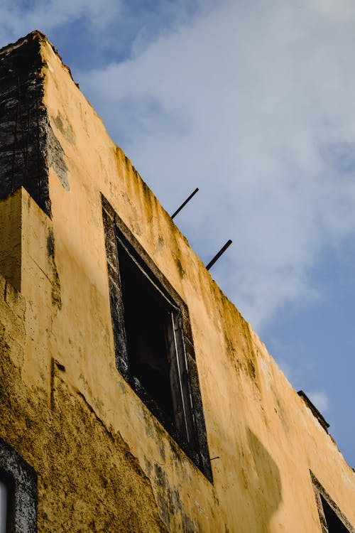 白云下的黄色混凝土建筑 · 免费素材图片