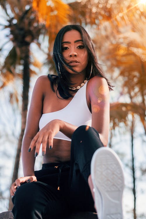 拿着黑色袋的白色背心的女人 · 免费素材图片