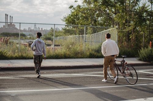 白衬衫骑自行车的人在路上 · 免费素材图片