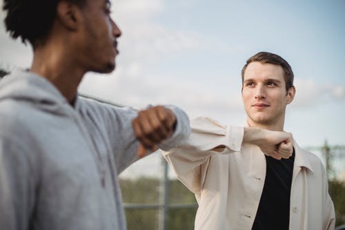 白色礼服衬衫的男人抱着黑色西装的男人 · 免费素材图片