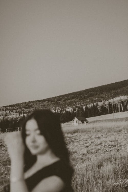 黑色衬衫站在草地上的女人 · 免费素材图片
