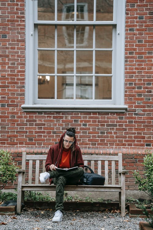 红色毛衣和黑色的裤子，坐在白色的木制窗框上的男人 · 免费素材图片