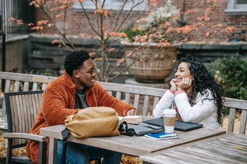 男人和女人坐在长凳上 · 免费素材图片