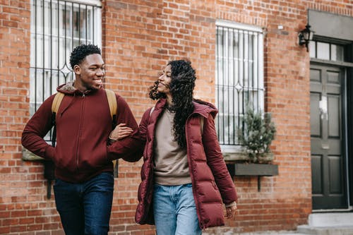 站在红色外套的女人旁边的红色毛衣的男人 · 免费素材图片