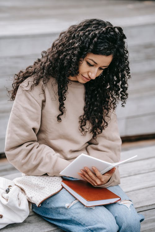 米色长袖衬衫阅读书中的女人 · 免费素材图片