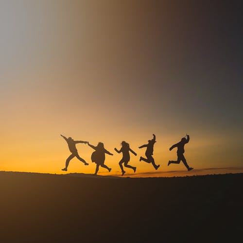 人们在日落时跳跃的剪影 · 免费素材图片