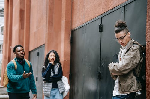 黑色围巾和白色外套站在棕色夹克的男人旁边的女人 · 免费素材图片