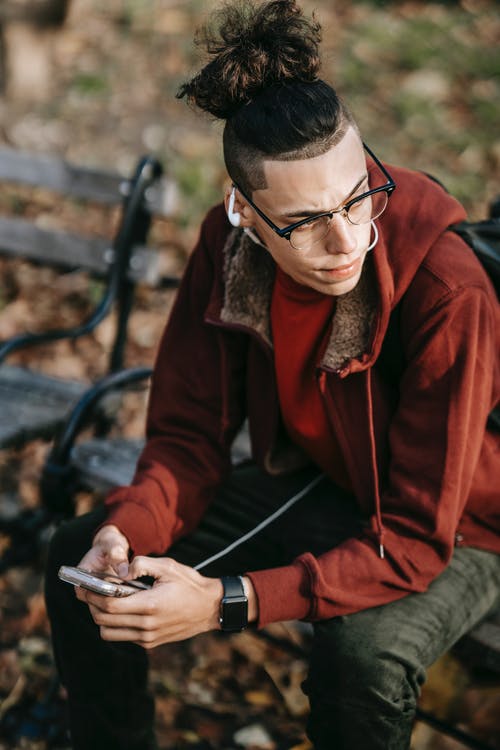 拿着智能手机的红色夹克的男人 · 免费素材图片