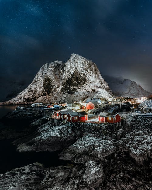夜间在落基山附近的水体上的人 · 免费素材图片