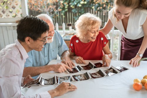 坐在男孩旁边的红色船员脖子t恤的男人 · 免费素材图片