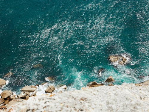 布朗多岩石的海岸，用蓝色的水 · 免费素材图片