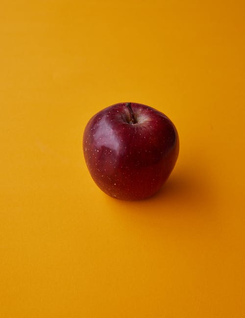 在黄色表面上的红苹果果实 · 免费素材图片