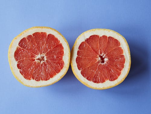 在蓝色的表面切成薄片的橙色水果 · 免费素材图片
