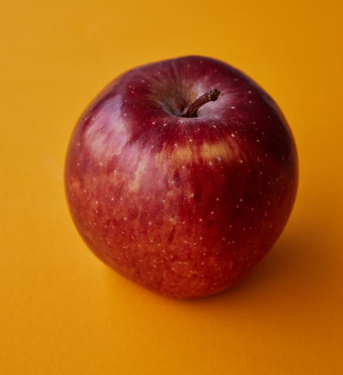 在黄色表面上的红苹果果实 · 免费素材图片