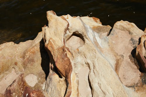 水上的棕色岩层 · 免费素材图片