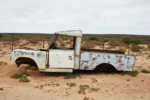 棕色土地面上的白色和棕色单座小卡车 · 免费素材图片