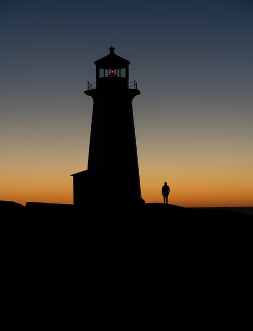 日落时灯塔的剪影 · 免费素材图片