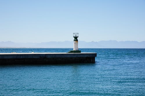 灰色混凝土码头上的白色灯塔 · 免费素材图片