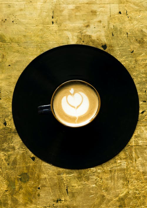 白色陶瓷杯咖啡在黑色的圆形板上 · 免费素材图片