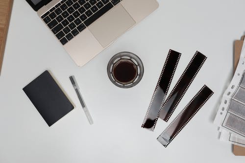 黑色笔和黑色笔记本旁边的macbook Pro · 免费素材图片