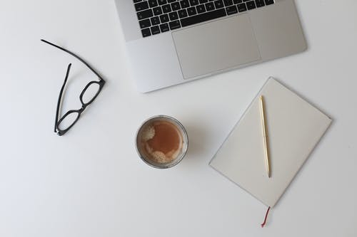 黑色框眼镜旁的macbook Pro · 免费素材图片