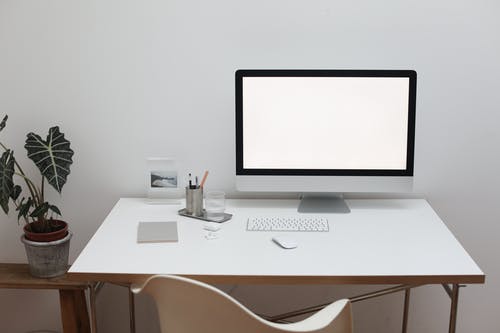白色的木桌上的银色imac · 免费素材图片