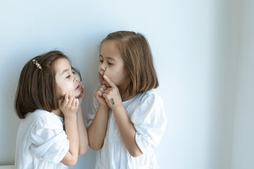 盖她的嘴的白衬衫的女孩 · 免费素材图片