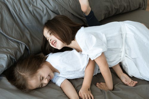 躺在灰色的床上的白衬衫的女孩 · 免费素材图片