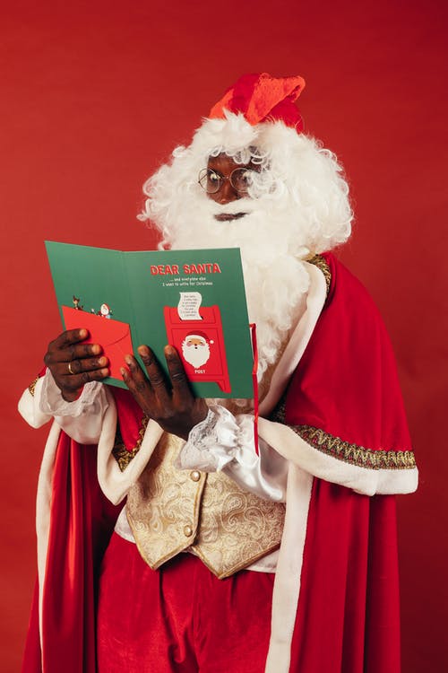 圣诞老人拿着绿皮书看起来很惊讶 · 免费素材图片