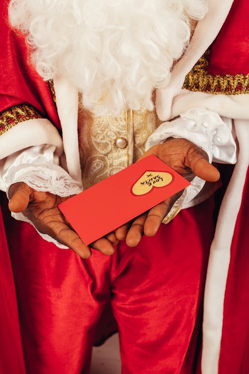 拿着圣诞信时穿圣诞老人衣服的人 · 免费素材图片