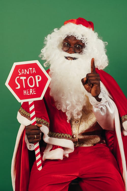 圣诞老人拿着红色和白色的停止标牌 · 免费素材图片