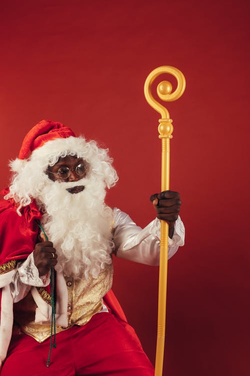 圣诞老人拿着红色背景上的黄色棍子 · 免费素材图片