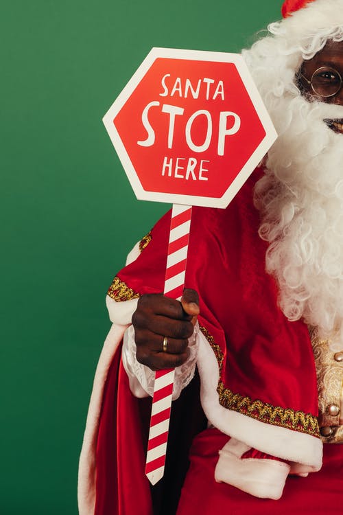 圣诞老人拿着红色和白色的停止标牌 · 免费素材图片