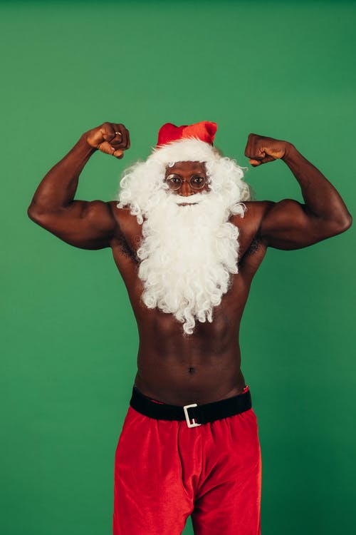 圣诞老人衣服展示肌肉的赤膊男子 · 免费素材图片