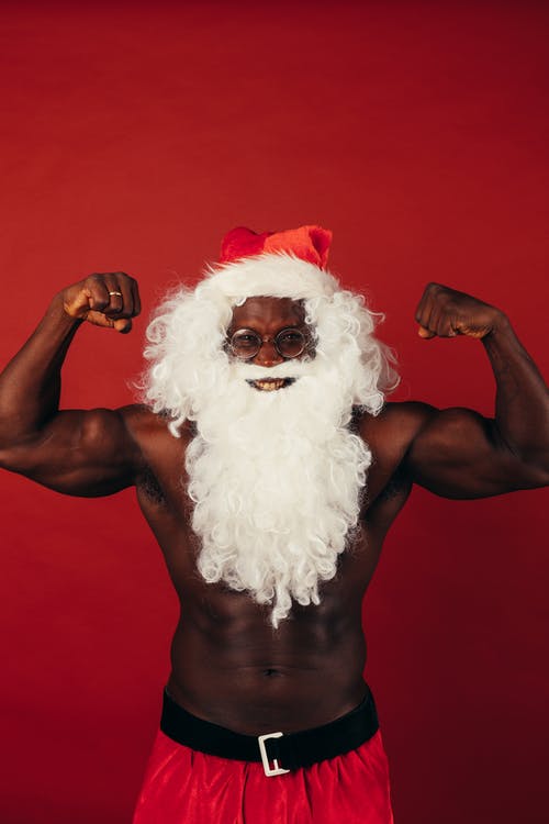 圣诞老人服装展示肌肉的男人 · 免费素材图片