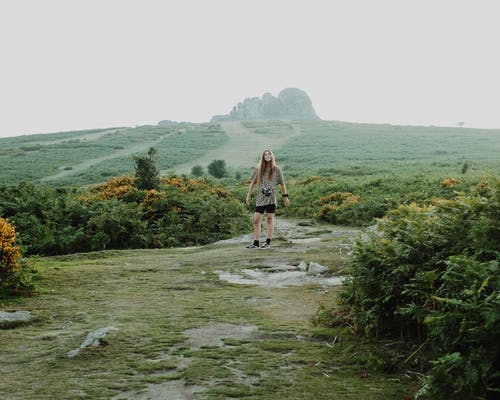 棕色外套和黑色的裤子，站在灰色的土路上的女人 · 免费素材图片
