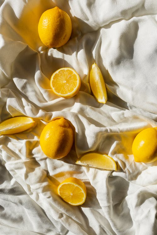 在白色纺织品上切成薄片的橙色水果 · 免费素材图片