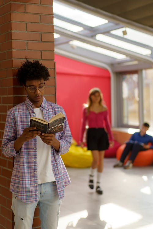 拿着黑色智能手机的白色和黑色格子衬衫的女人 · 免费素材图片