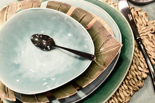 蓝色陶瓷碗上的不锈钢勺子 · 免费素材图片